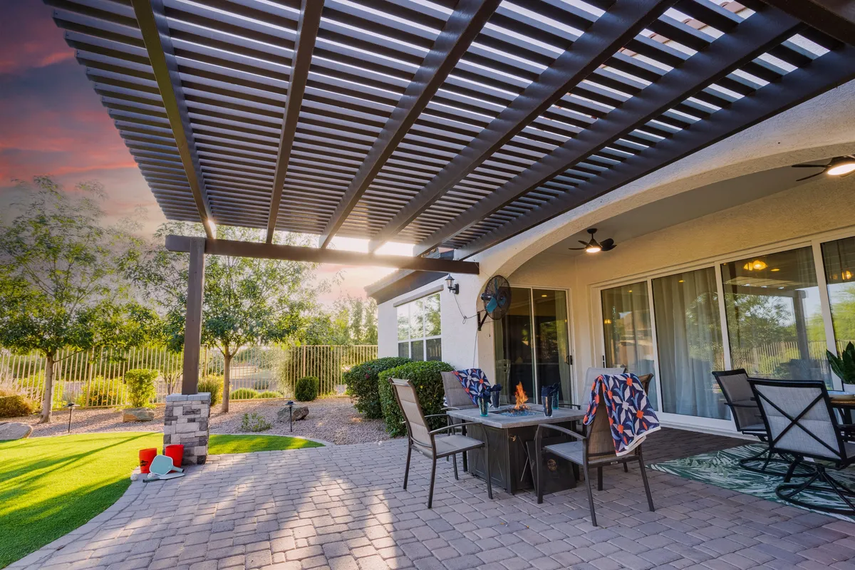 This exterior image features a welcoming pergola with an outdoor dining table set amidst a landscaped garden. Comfortable furniture and a lush green backdrop create an inviting setting for alfresco meals and gatherings, capturing the essence of dining and socializing outdoors.