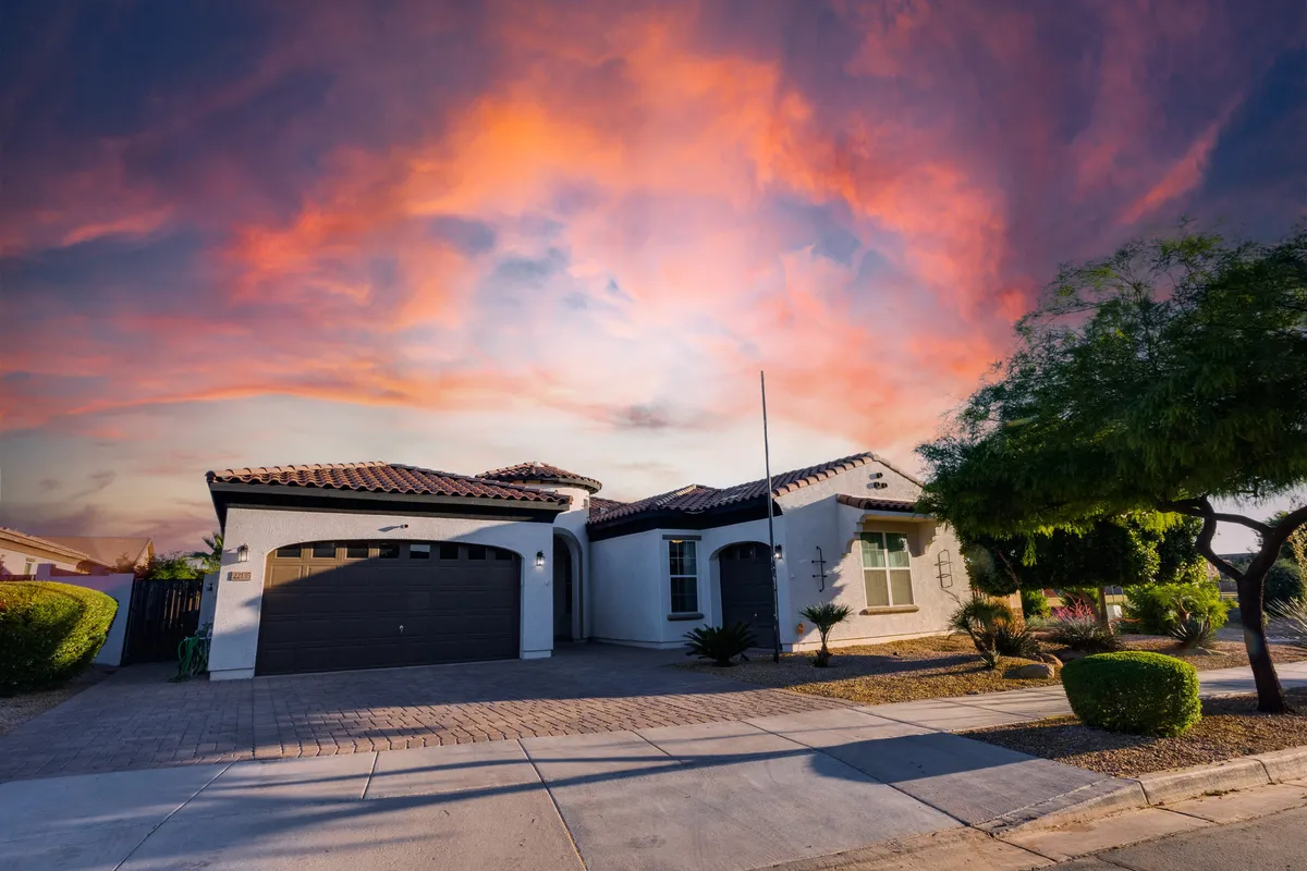 A welcoming view of the house’s exterior at dusk, with the landscaped garden and porch bathed in soft, evening light. The vibrant sky adds warmth and charm, suggesting inviting social spaces and comfortable gatherings.