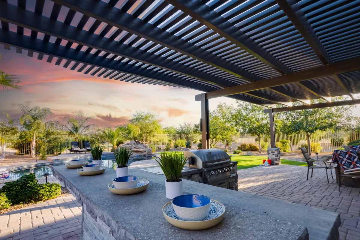 An inviting outdoor kitchen area with a grill, decorative bowls, and a meticulously landscaped garden, ideal for gatherings or sunset barbecues. The setting demonstrates spaces designed for entertaining and socializing after a day of active adventures.